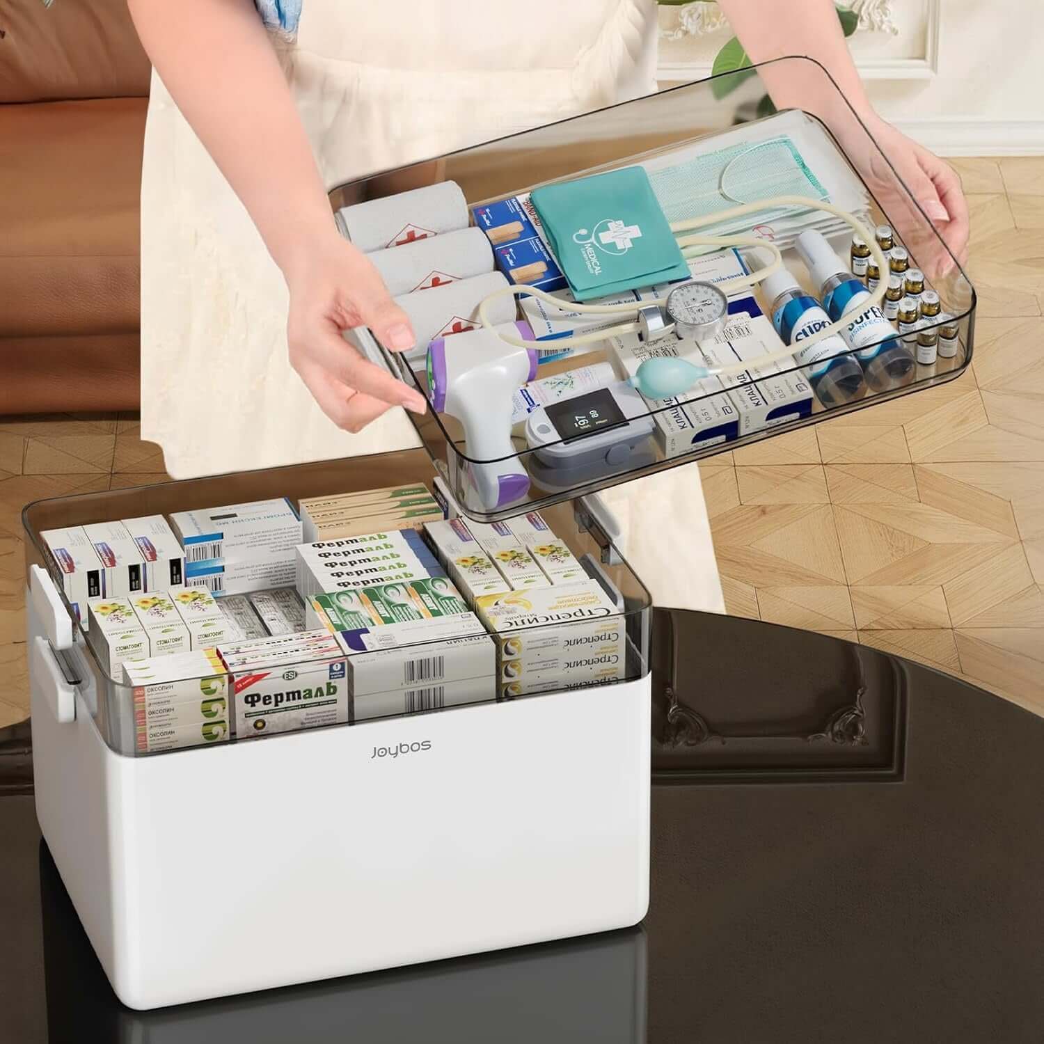 Person organizing a 3-tier medical storage box filled with health essentials and medications.